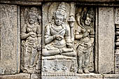 Prambanan, a male Hindu deity flanked on either sides by two female deities. These figures is probably devata and apsaras, the celestial maiden. The relief panel on the wall of Vishnu temple. 